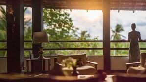 Ein Zimmer mit einem großen Fenster, einer Lampe und zwei Stühlen.
