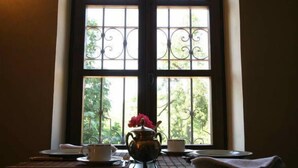 Una mesa con tetera y tazas junto a una ventana con vistas a la vegetación.