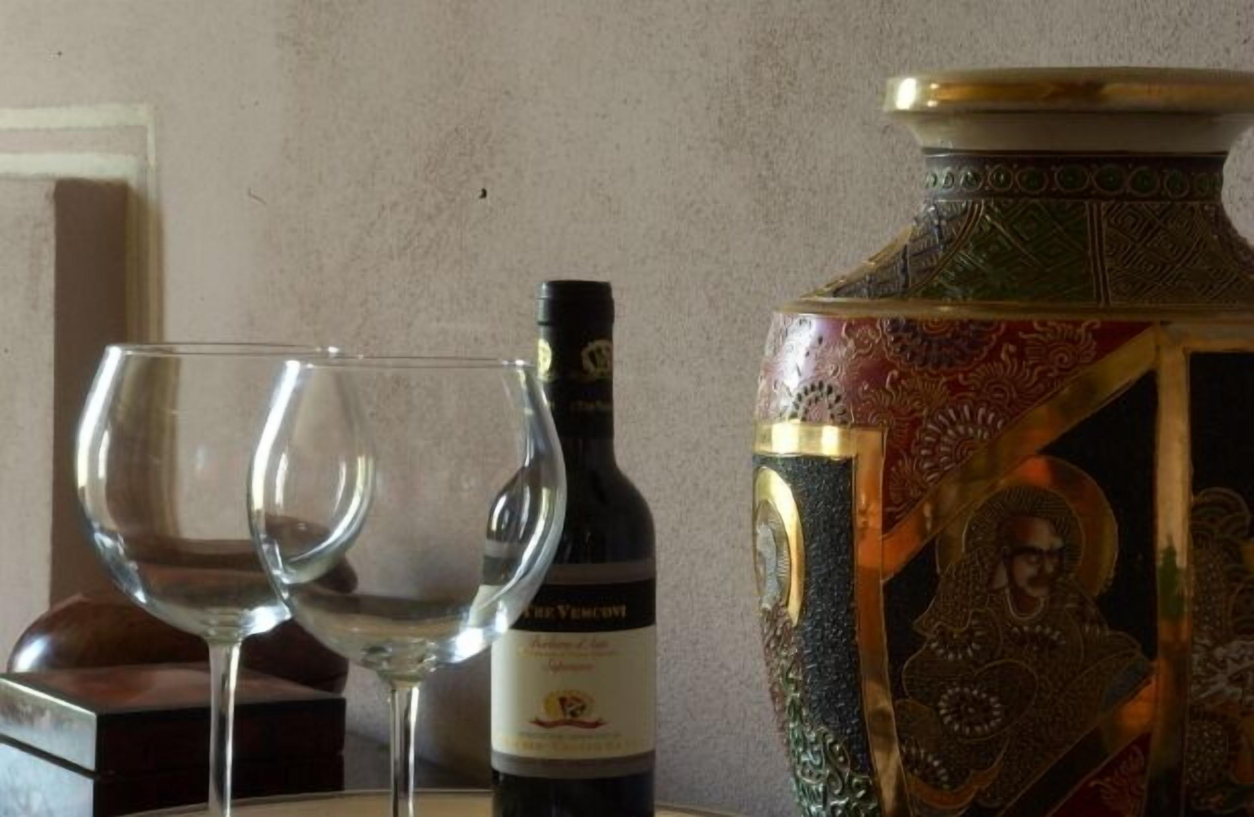 Een fles wijn en twee wijnkaraffen op een tafel.
