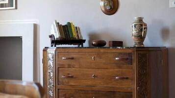 Un meuble en bois avec plusieurs tiroirs, un vase et des livres posés sur le dessus.