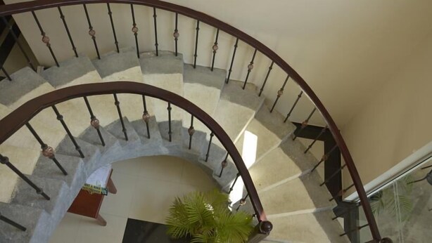 A curved staircase with a handrail and balusters, leading to an upper floor. - Blue Coast View (Negombo)