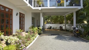 A two-story building with a covered entrance, potted plants, and a motorcycle parked outside. - Blue Coast View (Negombo)