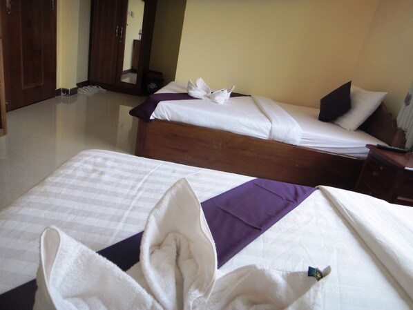 A hotel room with two beds, a wooden headboard, and a mirror. - Khemra I Guesthouse (Kampot)
