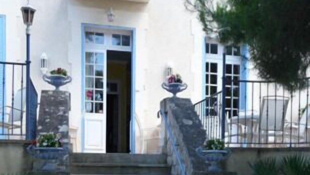 Un bâtiment doté d’un escalier en pierre menant à une porte.