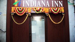 A hotel entrance with a sign reading "Hotel Indiana Inn" and decorative garlands. - Hotel Indiana Inn (Navi Mumbai)