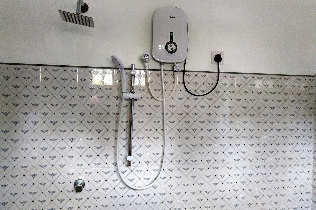 A shower with a handheld showerhead and a wall-mounted control panel.