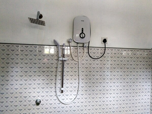 Ducha con cabezal de ducha de mano y panel de control en la pared.