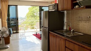 Una cucina moderna con mobili in legno, un frigorifero nero, un forno a microonde e un lavello.