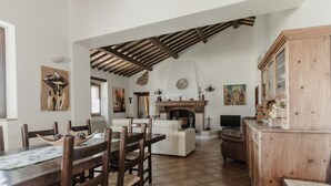 Un salón amplio con chimenea, muebles de madera y obras de arte en las paredes.
