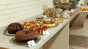 Een buffet met diverse desserts en ontbijtproducten.