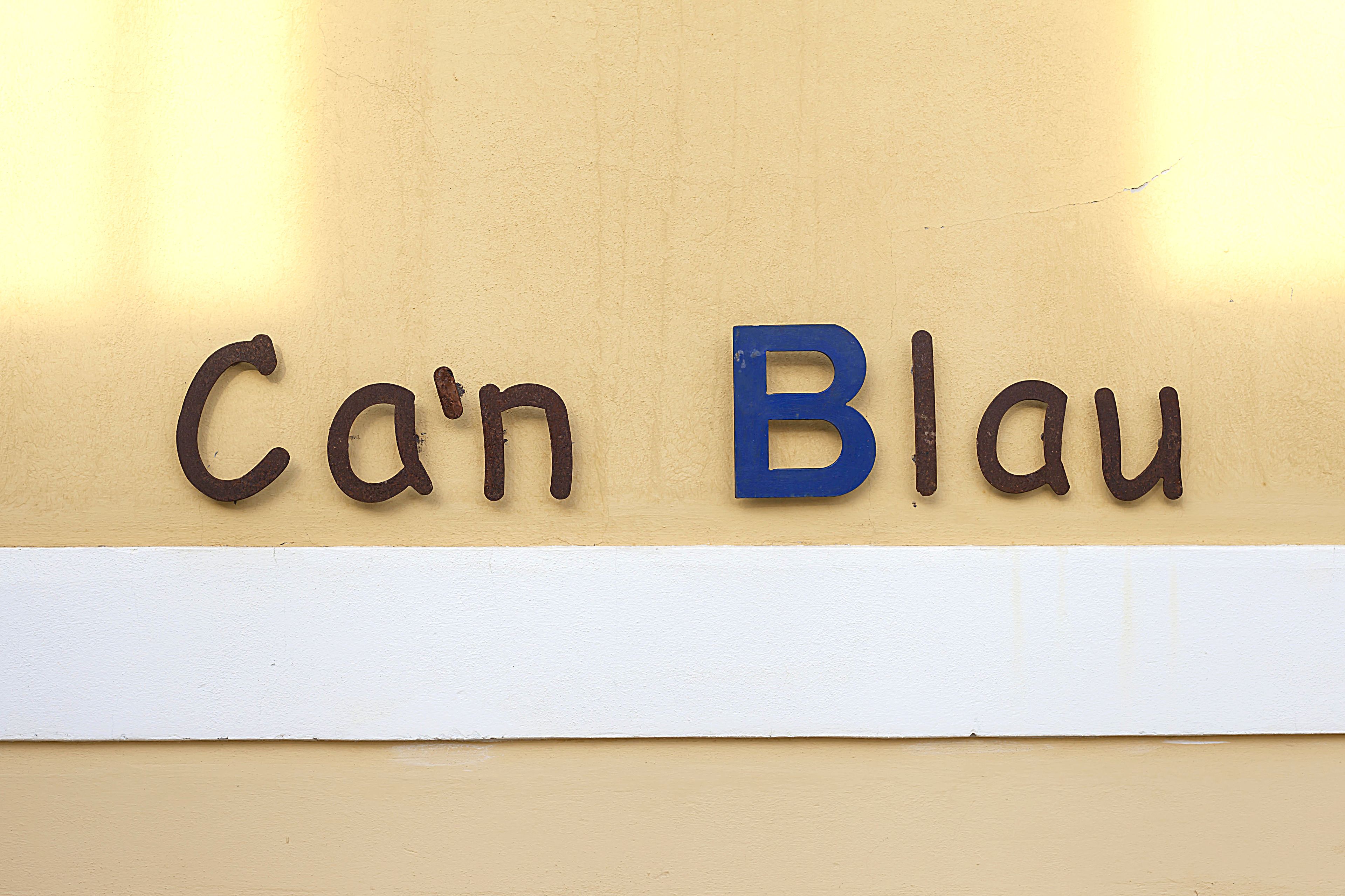 Une enseigne portant l’inscription « Ca’n Blau » sur un mur de couleur beige.