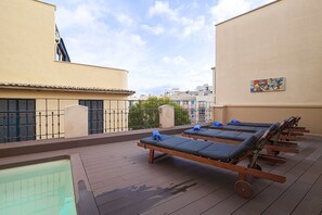 Una piscina al aire libre, tumbonas