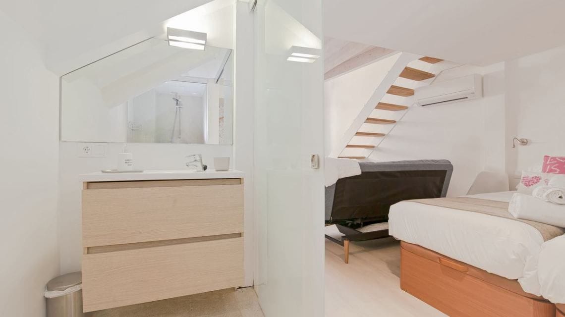 Un dormitorio moderno con un aparador de madera, una cama, una silla y una escalera.