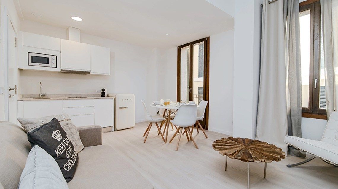 A modern apartment with a kitchen, dining area, and living space.