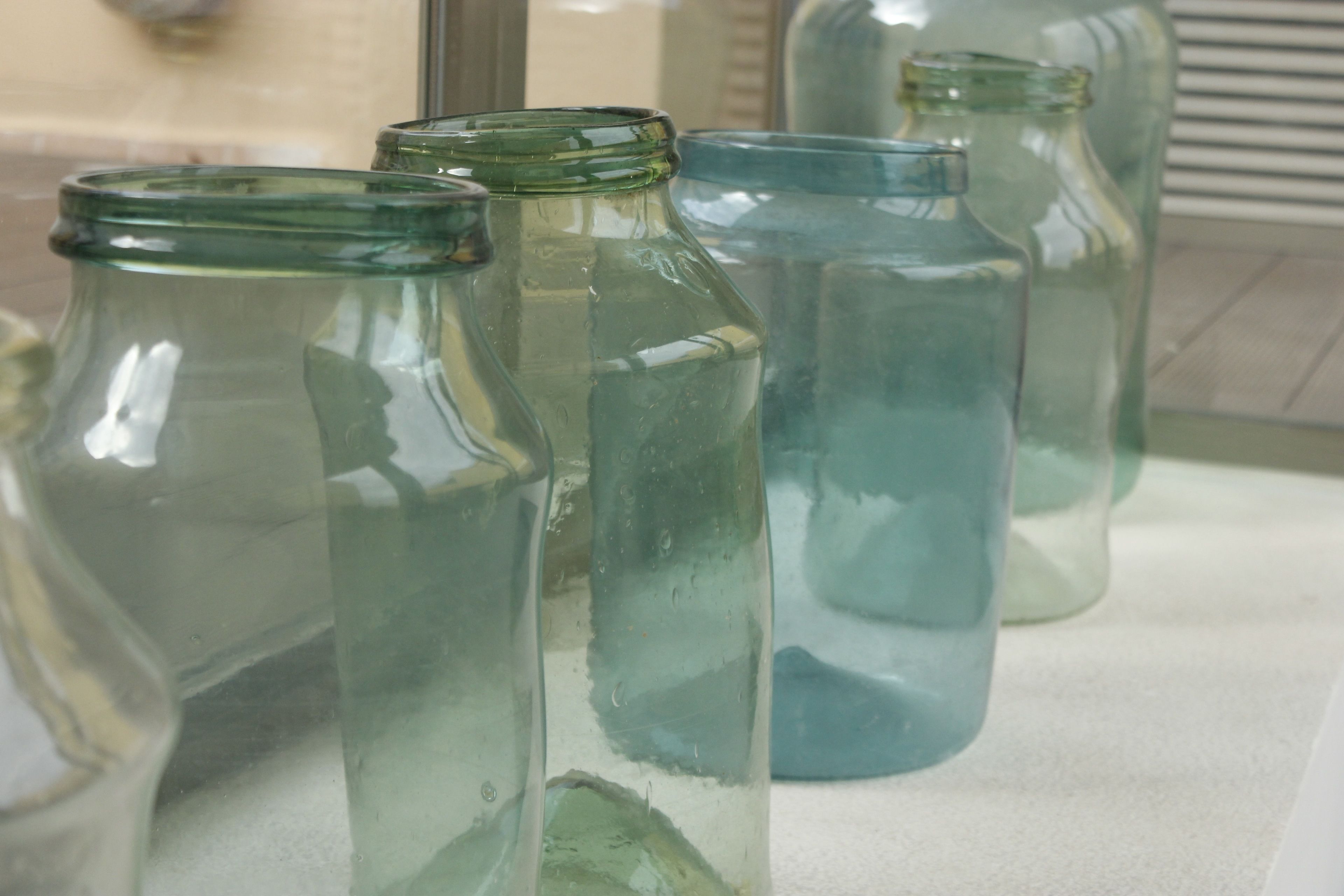 Several glass bottles of varying sizes on a shelf.
