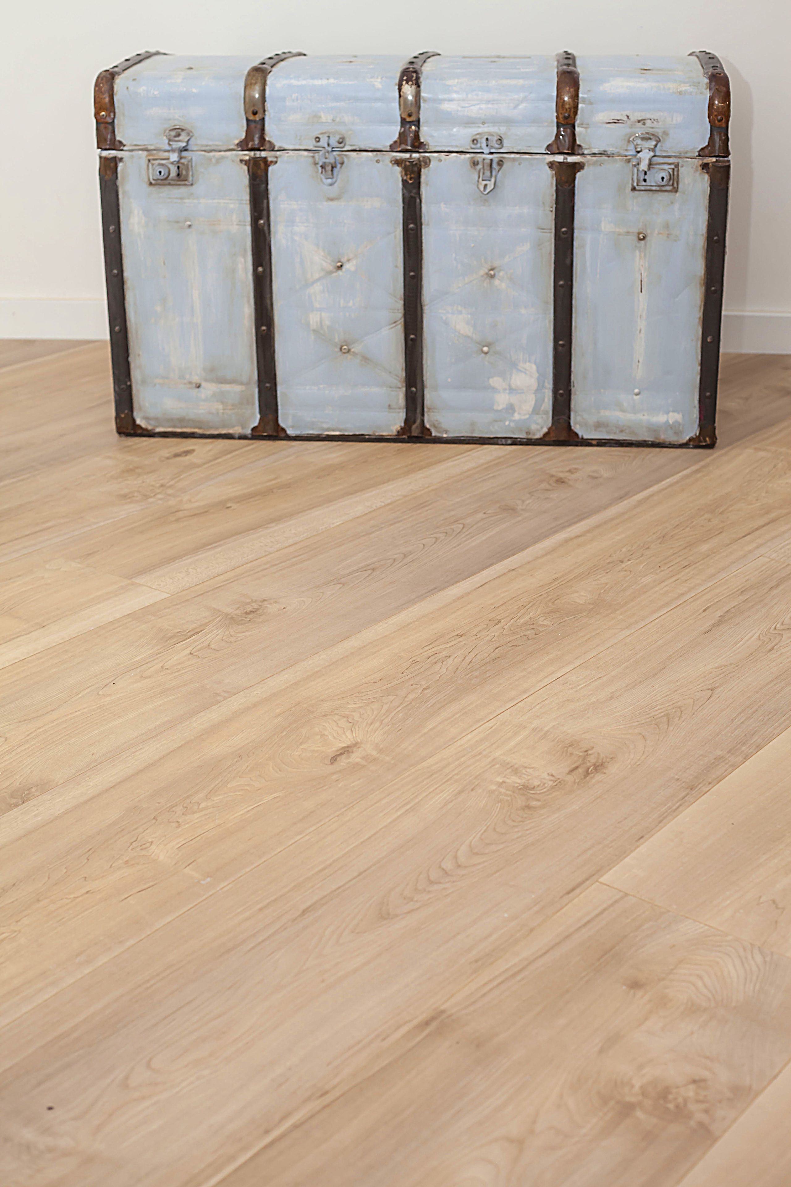 Un conjunto de cuatro baúles de estilo vintage con cierres metálicos, sobre un piso de madera frente a una pared lisa.