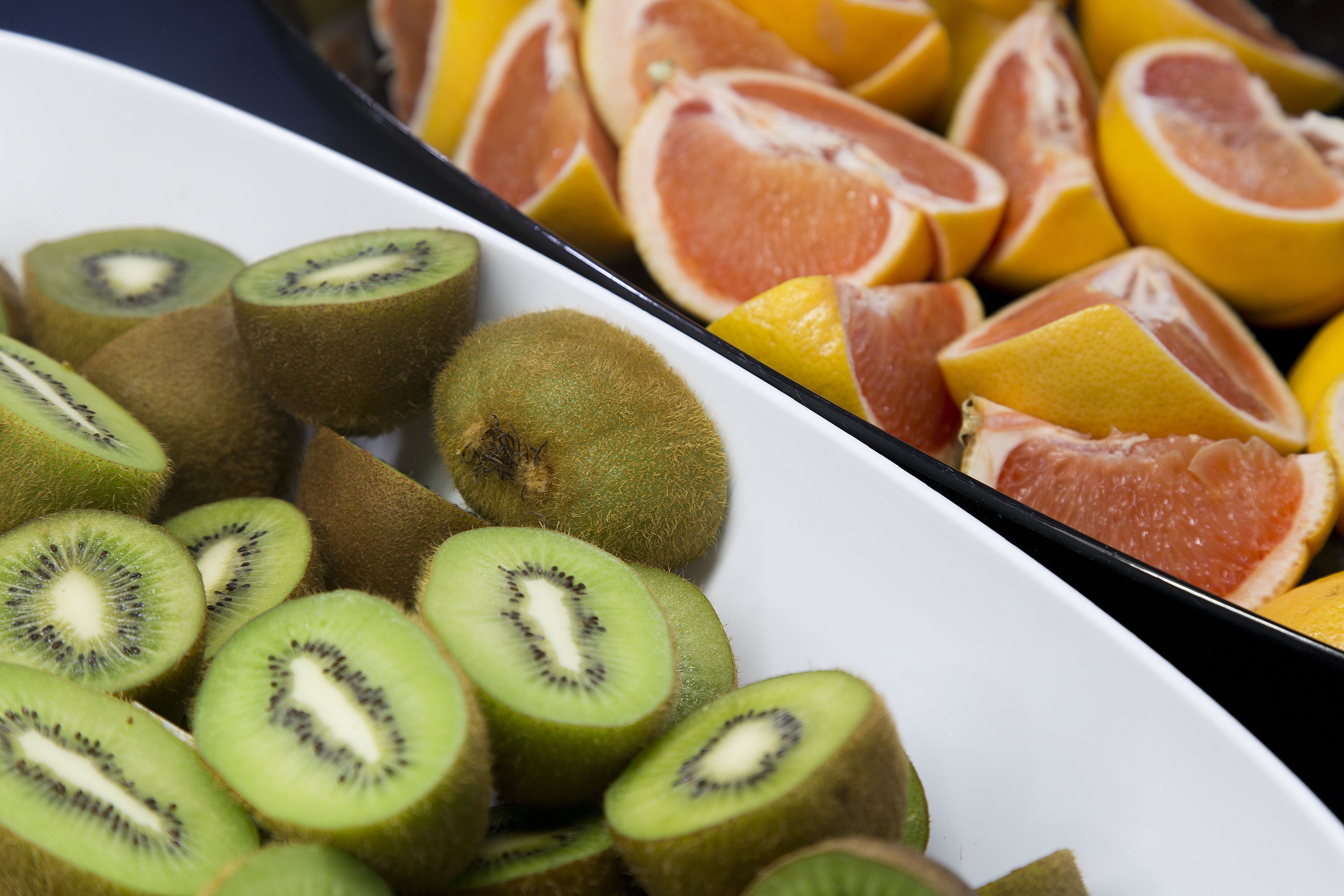A tray of sliced kiwi and grapefruit.