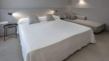 Un dormitorio moderno con una cama grande, mesitas de noche y un banco empotrado.