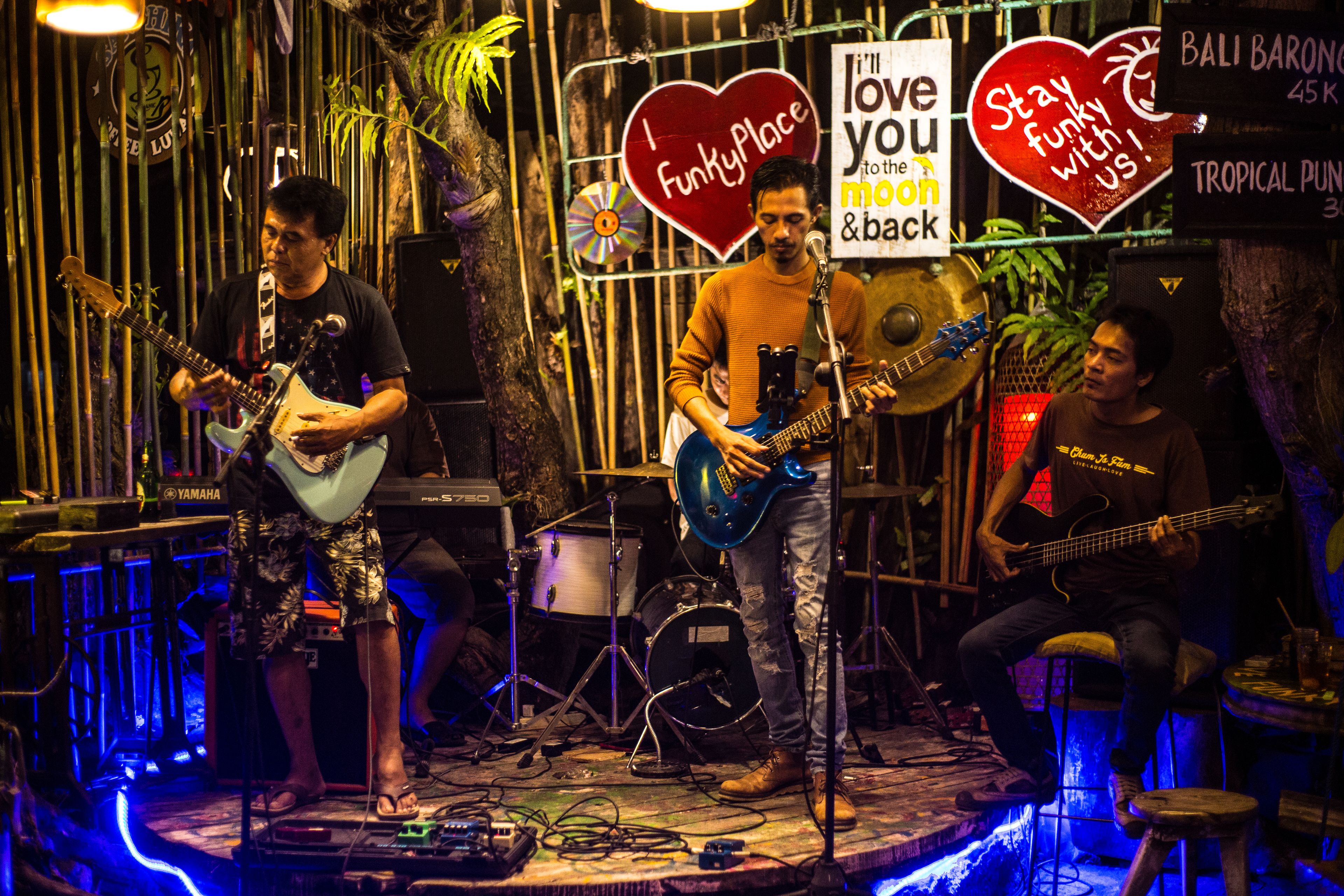 Una banda actuando en un escenario con instrumentos musicales y una batería.