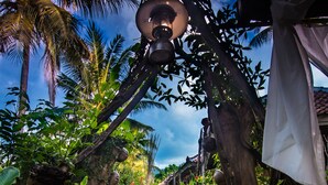 A pathway lined with tropical plants and a lamp post. - FunkyPlace (Buleleng)