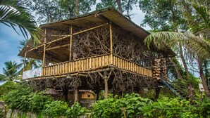 A bamboo structure with a balcony, surrounded by lush greenery. - FunkyPlace (Buleleng)