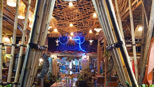An indoor space with bamboo structures, tables, chairs, and potted plants. - FunkyPlace (Buleleng)