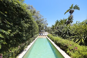 Una piscina al aire libre, tumbonas