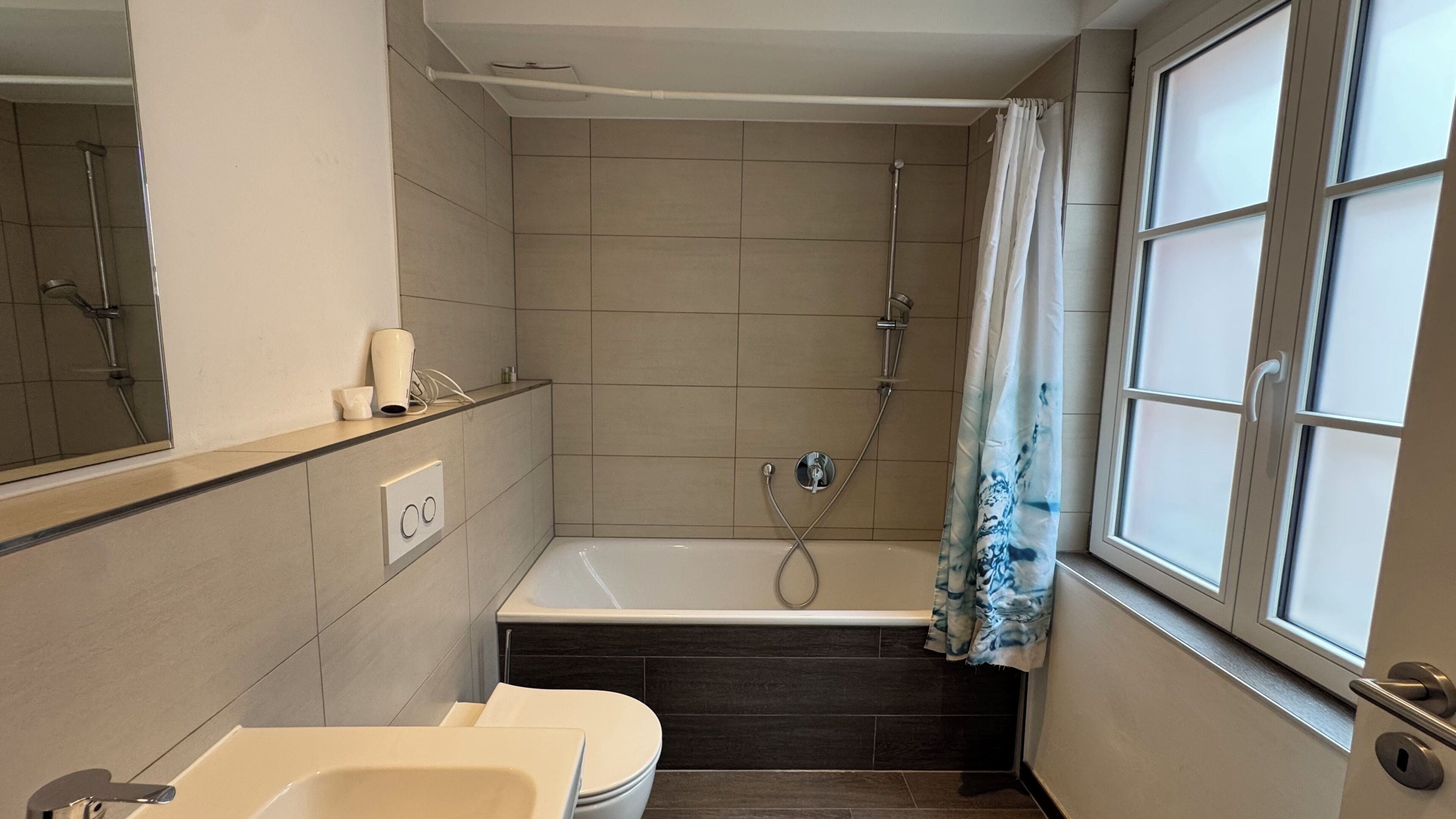 A bathroom with a bathtub, a shower, a toilet, and a sink.