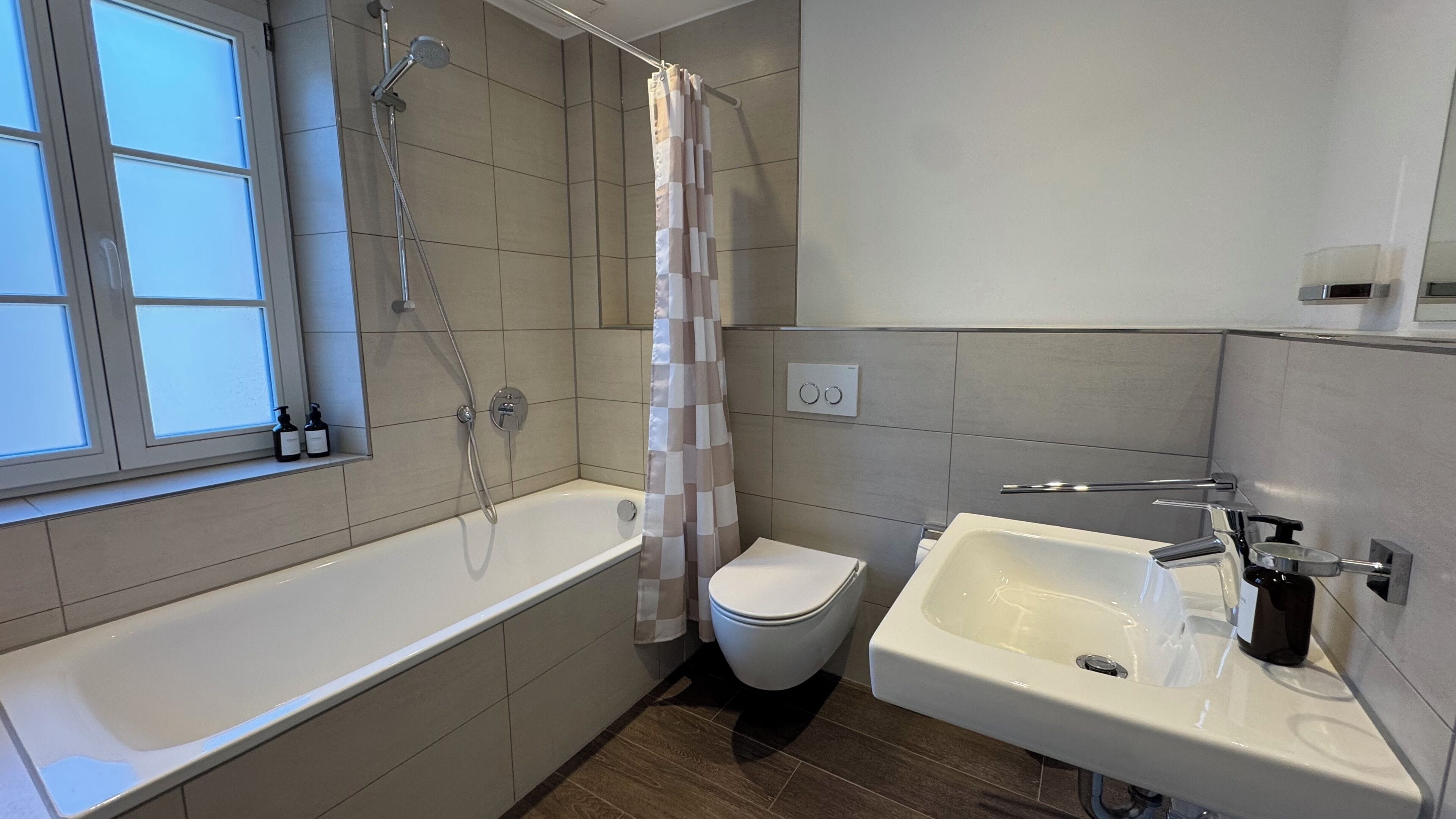 Ein modernes Badezimmer mit Badewanne, Toilette und Waschbecken.