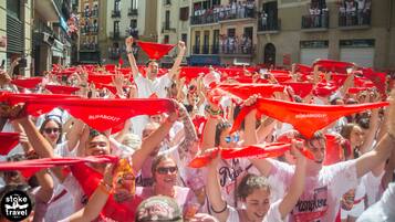 A group of people holding red flags in a crowded street.