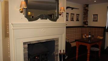 A room with a fireplace, a mirror, and a table with chairs.