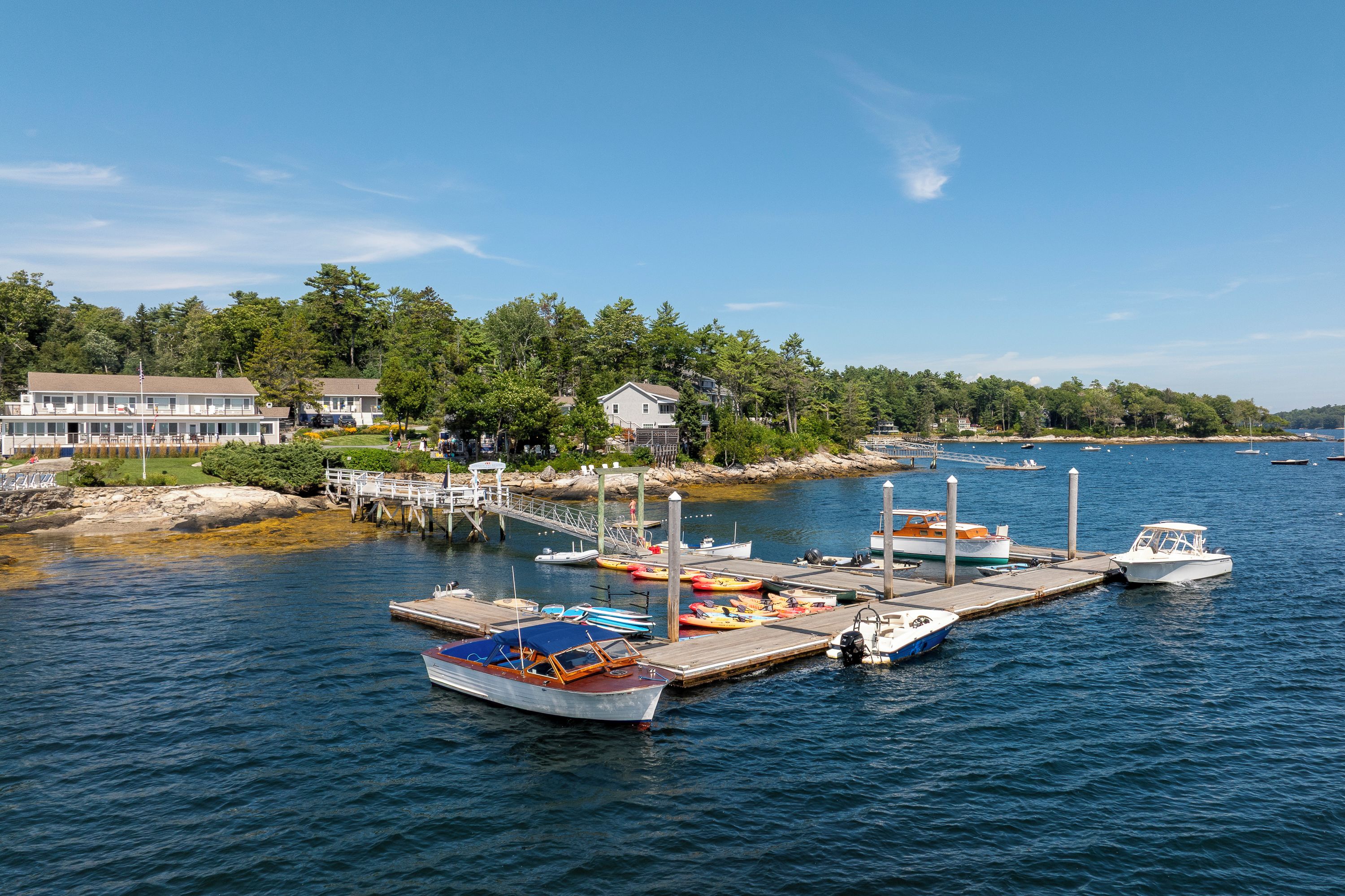 A marina with boats docked, a pier, and a building with a flag.