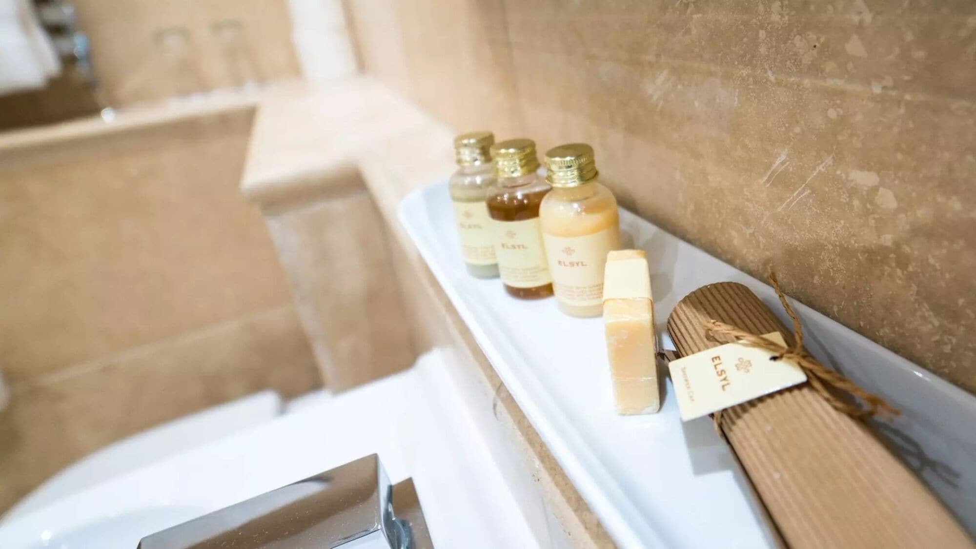 A bathroom shelf with toiletries including bottles and a wooden brush.