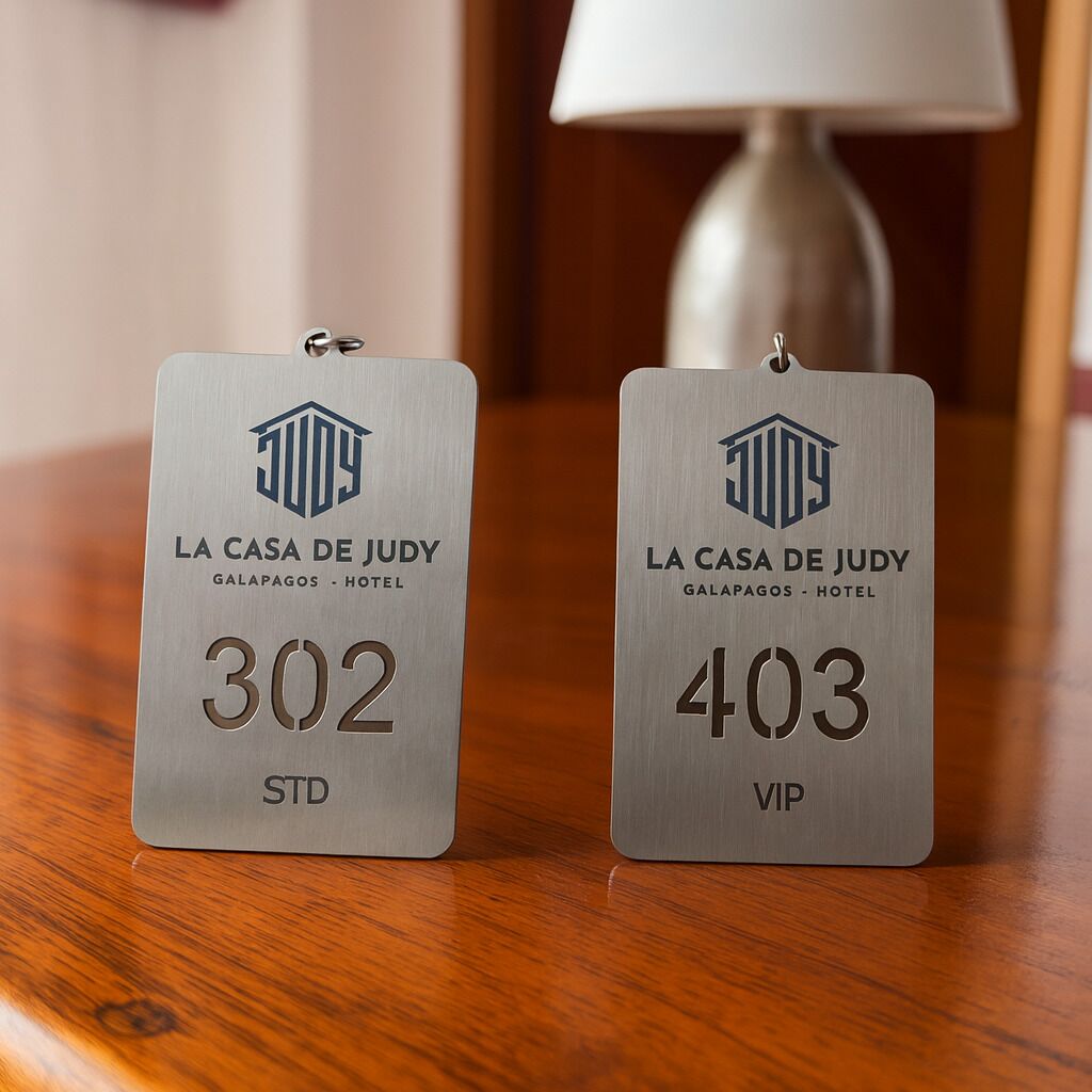 Dos etiquetas metálicas sobre superficie de madera, una con la etiqueta '303 STD' y otra '403 VIP' en La Casa de Judy, Galápagos - Hotel.