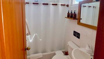 A bathroom with a toilet, sink, and shower curtain.