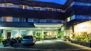 A modern hotel with a covered entrance, parked cars, and a sign reading "RINAYA". - The Rinaya Canggu (Tibubeneng)