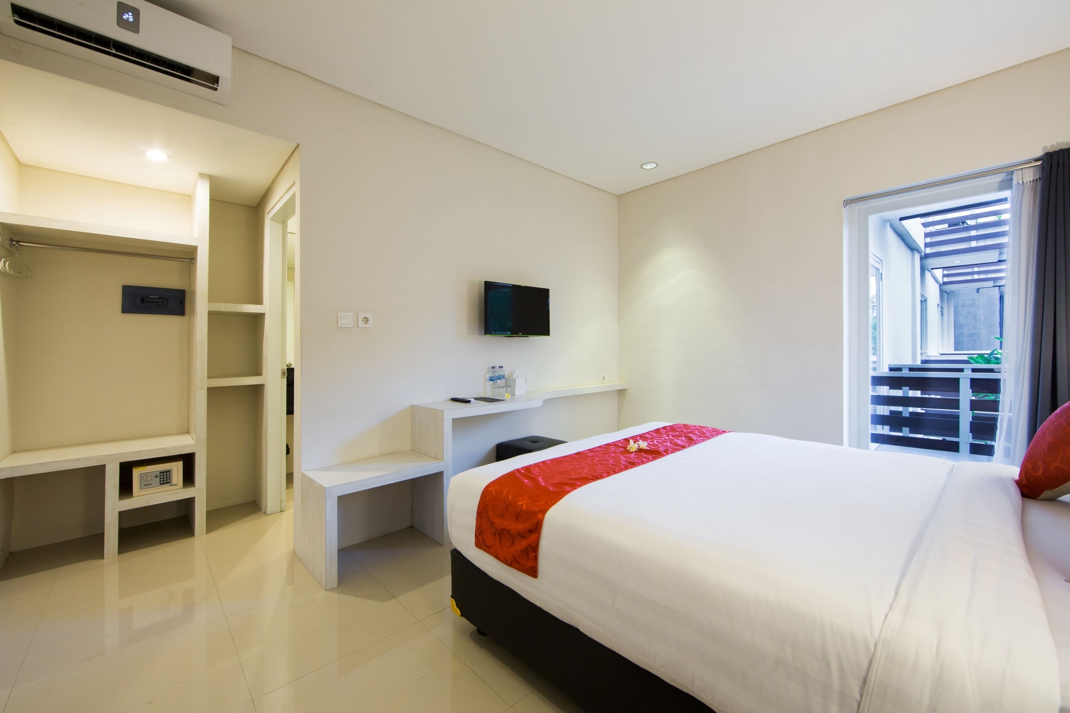 A hotel room with a bed, a TV, a desk, and a wardrobe.