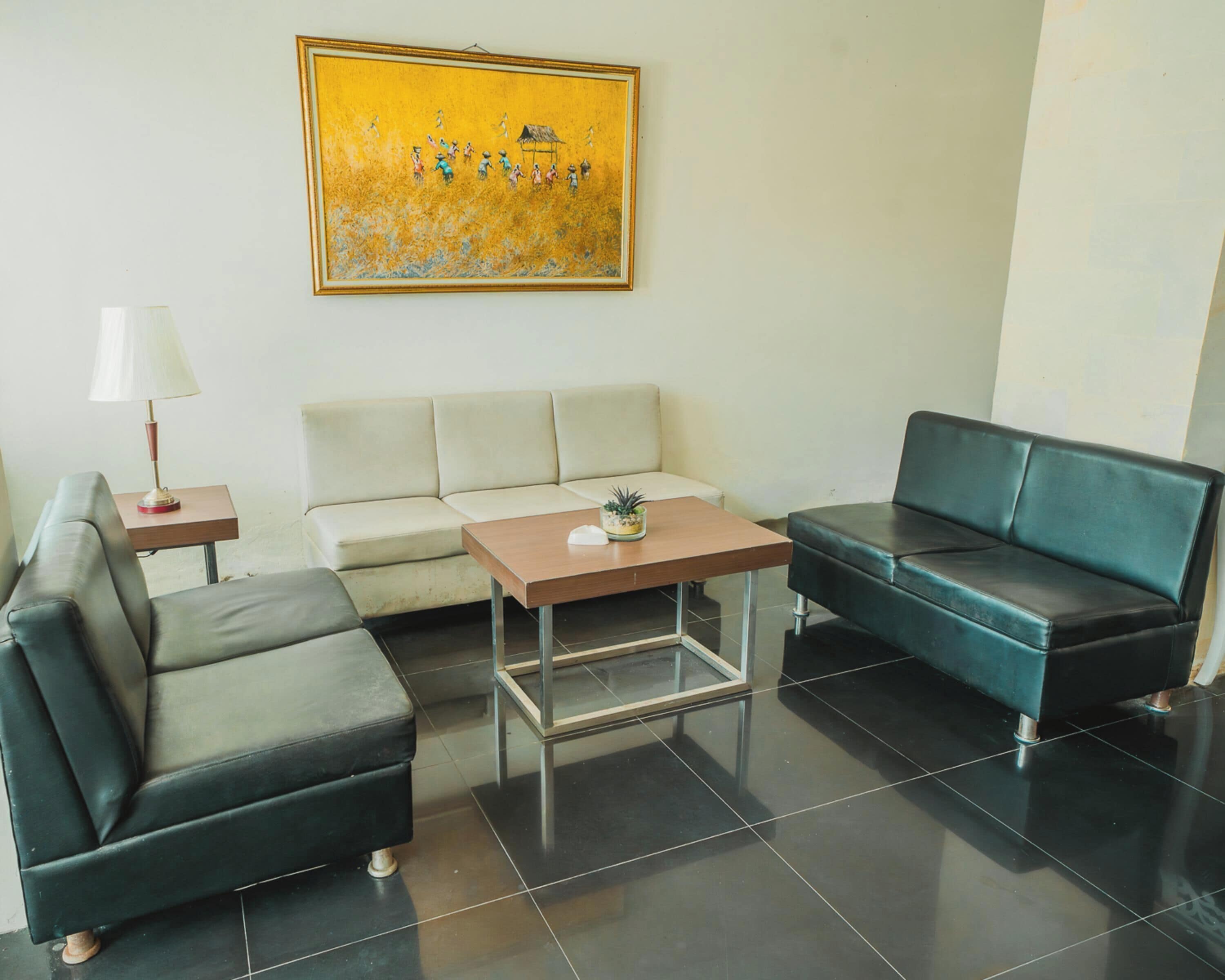 A modern living room with a sofa, a couch, a coffee table, and a lamp.