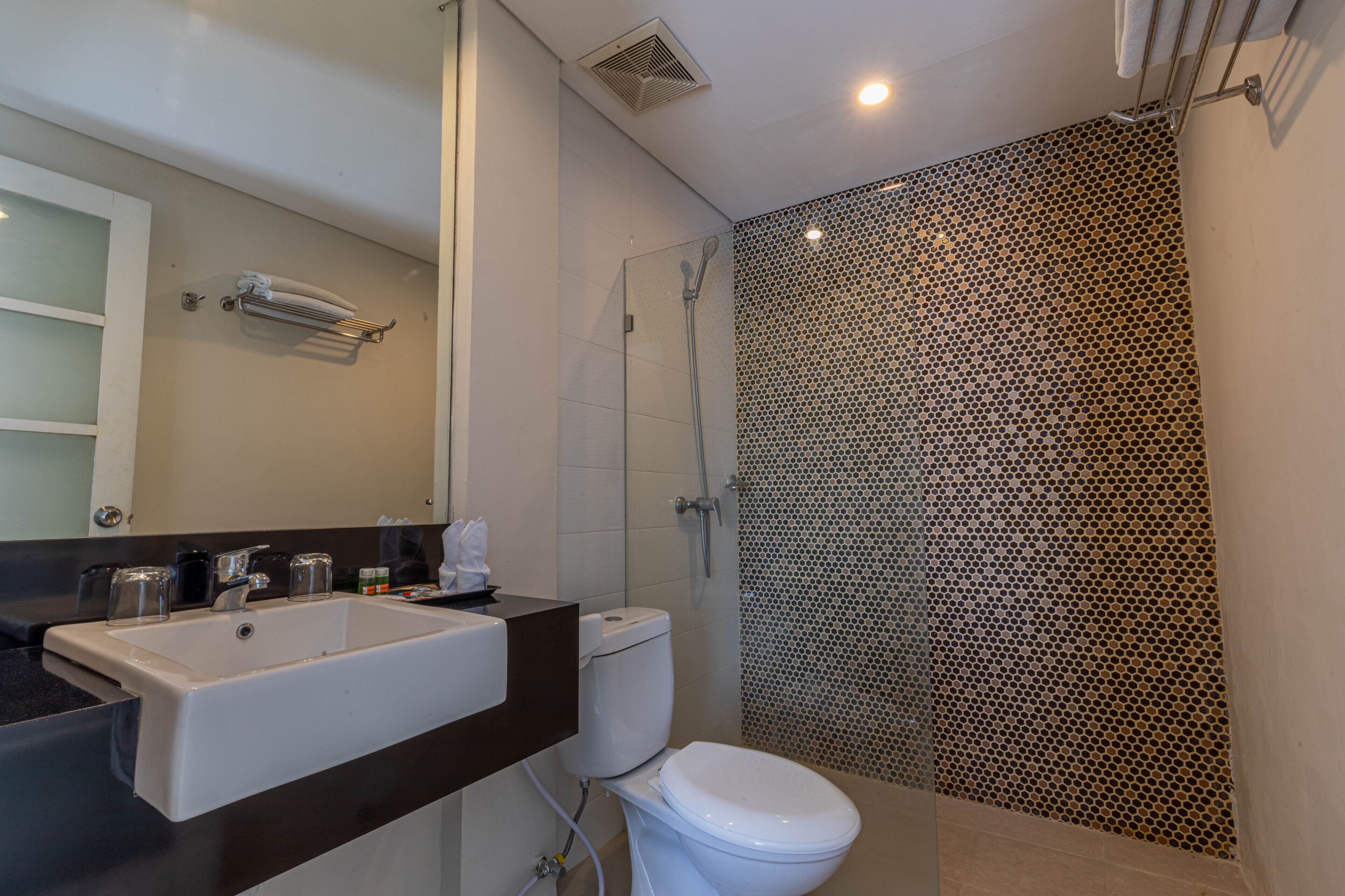 A modern bathroom with a large sink, toilet, and shower area.
