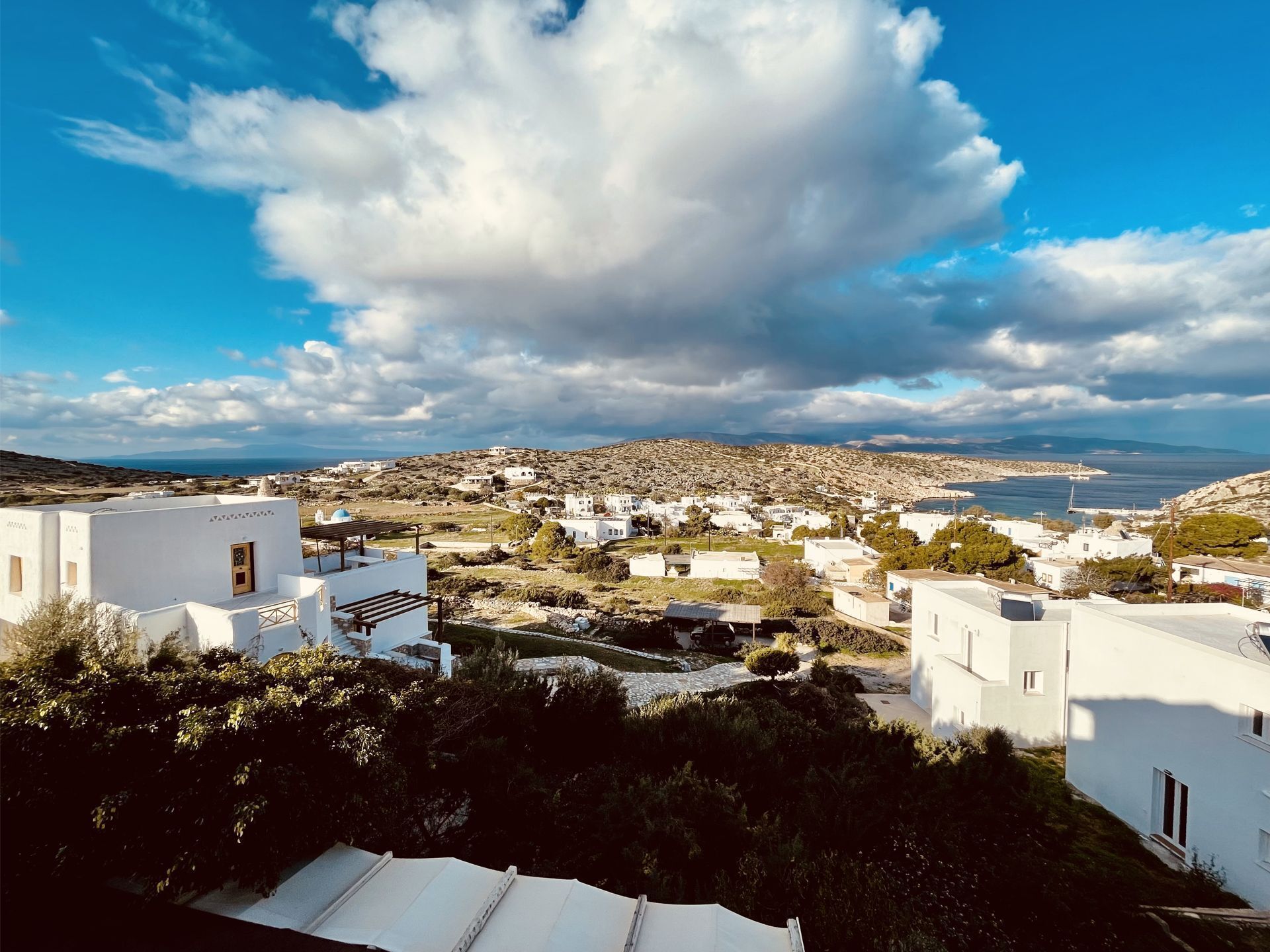 A coastal town with white buildings, a clear sky, and a view of the sea.