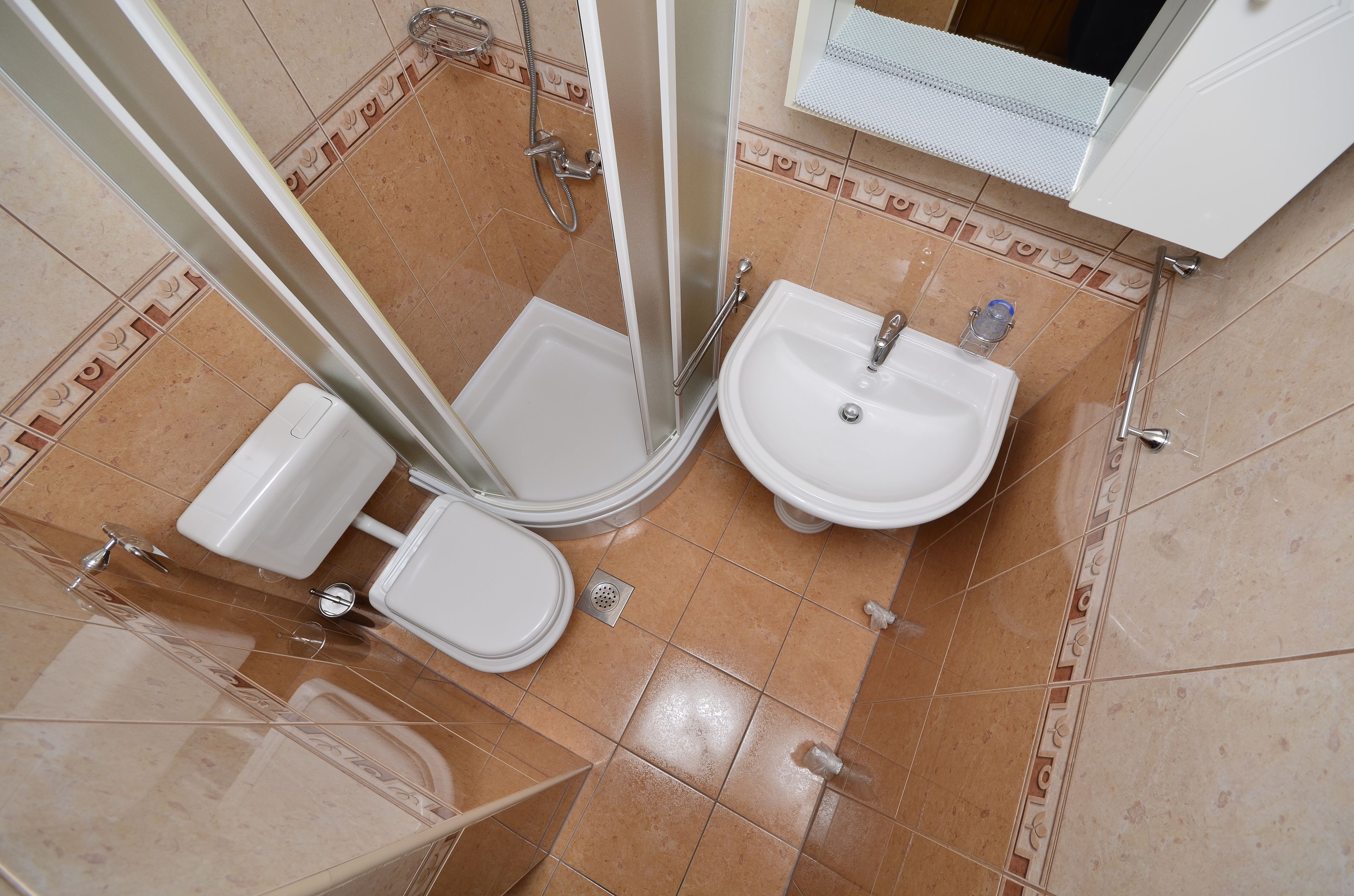 A bathroom with a shower, toilet, and sink.