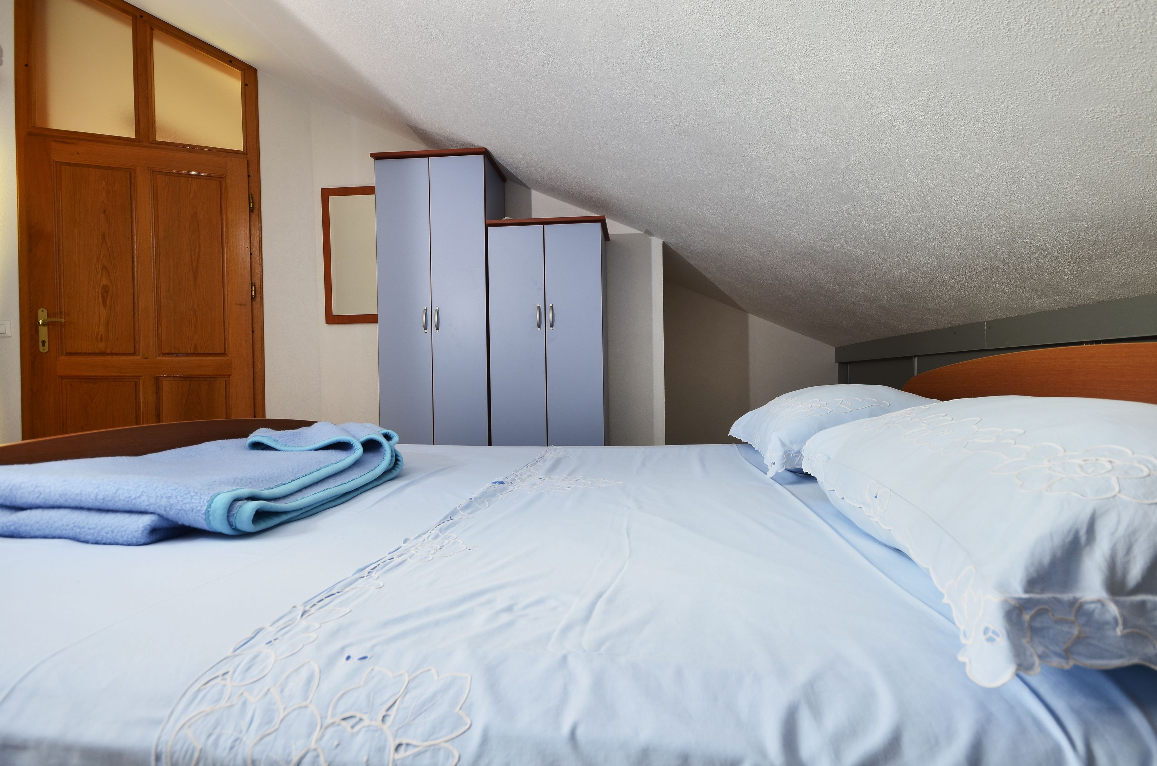 Ein Schlafzimmer mit einem Bett, einer Holztür und zwei Kleiderschränken.