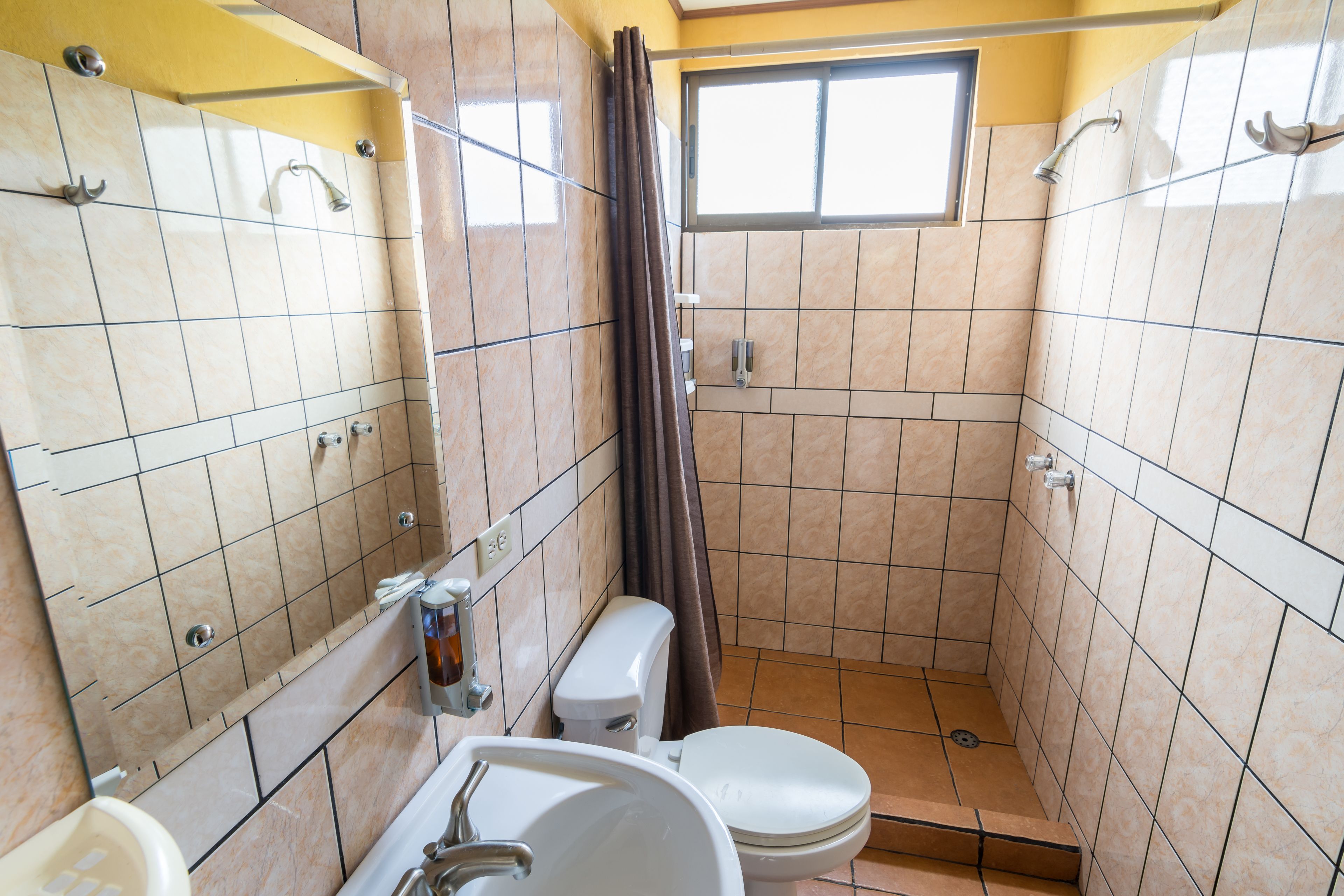A bathroom with a toilet, sink, and shower.