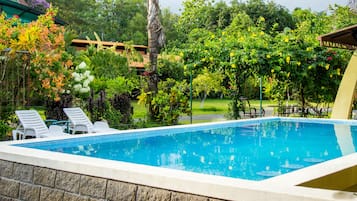 Una piscina al aire libre, una piscina con cascada