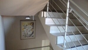 A staircase with a metal handrail and a beige wall. - Hotel Alves (Goiania)
