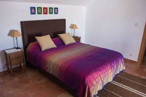 A bedroom with a large bed, two nightstands, and a wall-mounted lamp. - Casas da Moagem Turismo Rural (Santiago do Cacém)