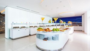 A modern buffet setup with various food items and a clean, white interior.