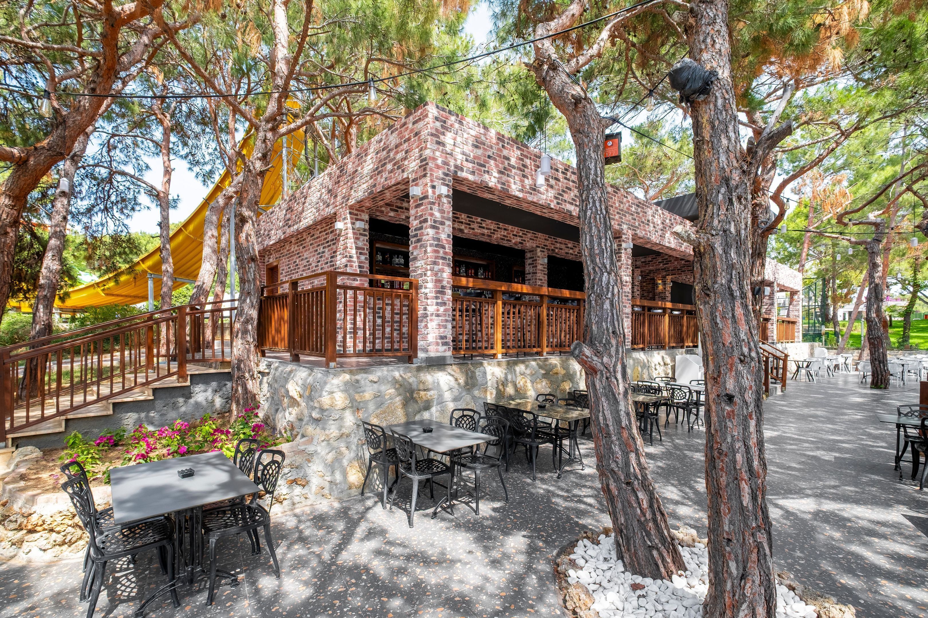 An outdoor patio area with brick walls, wooden furniture, and a stone pathway.