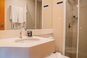 A bathroom with a sink, mirror, and shower.