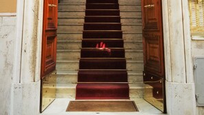 Une entrée imposante avec un escalier en marbre menant à une pièce comprenant un lit et une fenêtre.